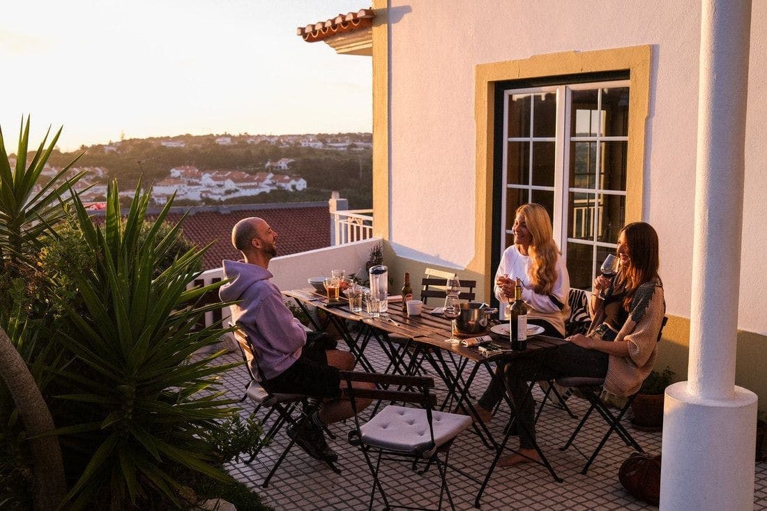Coworksurf guests spending time together on a terrace at sunset.
